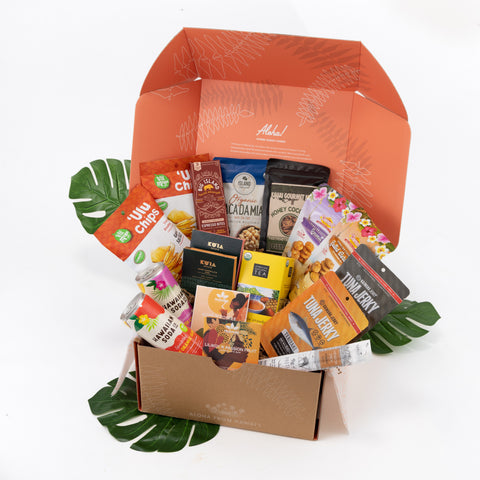 Assorted snacks in a box with visible brand names on a white background