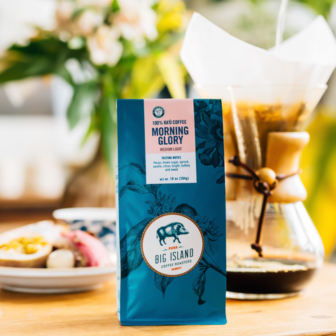 Blue coffee bag labeled 'Morning Glory' from 'Big Island' on a table with a blurred background