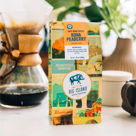 Kona Peaberry coffee package with a coffee-making setup in the background