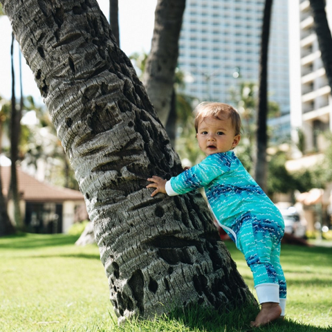 baby in blue and white onesie outside
