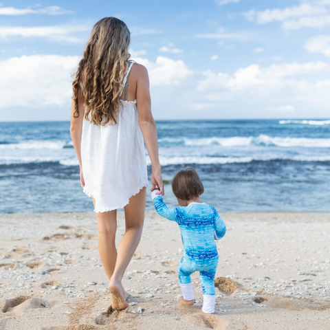 mom and baby walking to ocean in coco moon nalu onesie 