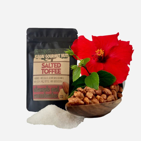 Kauai Gourmet Nuts salted toffee package with a bowl of toffee, sugar, and a red flower on a white background