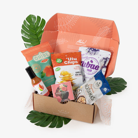 Snack box with various food items and a decorative leaf on a white background