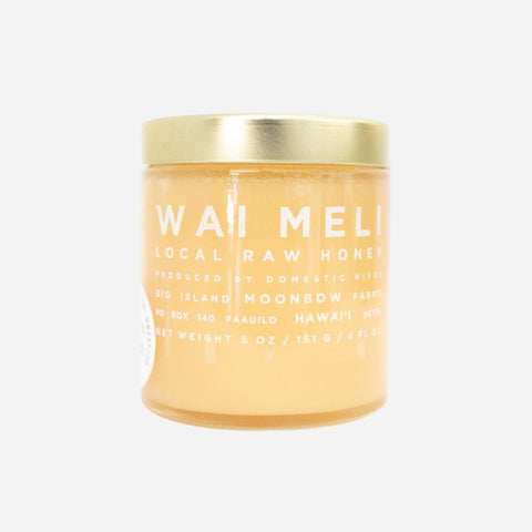 Jar of Wai Meli local raw honey with a gold lid on a white background