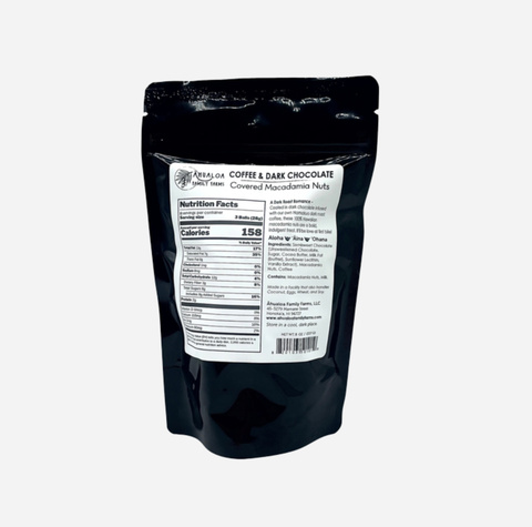 A black stand-up pouch of Bella+Canvas Coffee & Dark Chocolate Covered Macadamia Nuts, showing the back of the package with a white nutrition facts label on a light gray background.