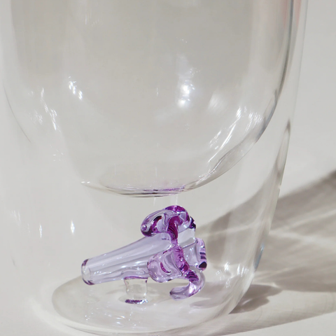 Clear glass mug with a purple object inside on a white background