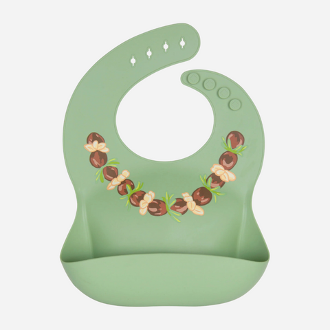 A green silicone bib with an illustrated pattern of kukui nuts.