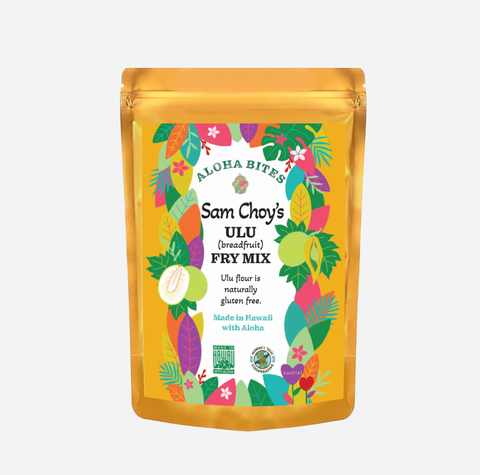 A stand-up pouch of Aloha Bites Sam Choy's Ulu (breadfruit) Fry Mix, featuring a bright yellow-gold packaging with a colorful tropical leaf and fruit illustration on the front label.