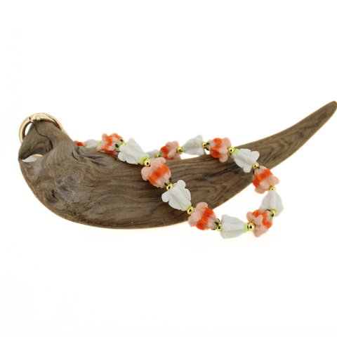 purse lei with orange and white floral beads on a wooden background