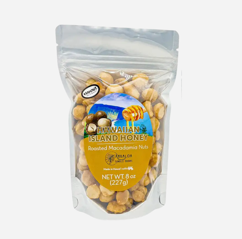 A 8 oz stand-up pouch of Hawaiian Island Honey Roasted Macadamia Nuts on a clean white background. The clear bag shows the golden-brown nuts inside, with a prominent yellow and blue label featuring the product name and a honeycomb graphic.