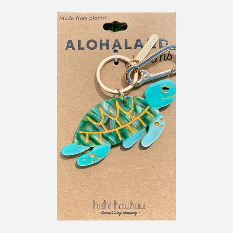 Turtle-shaped keychain on a brown card with 'Aloha Land' branding
