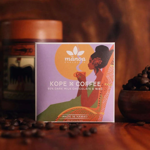 Manoa Kope x Coffee packaging with coffee beans on a wooden surface