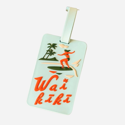Luggage tag with 'Waikiki' design featuring a surfer and palm trees on a light blue background