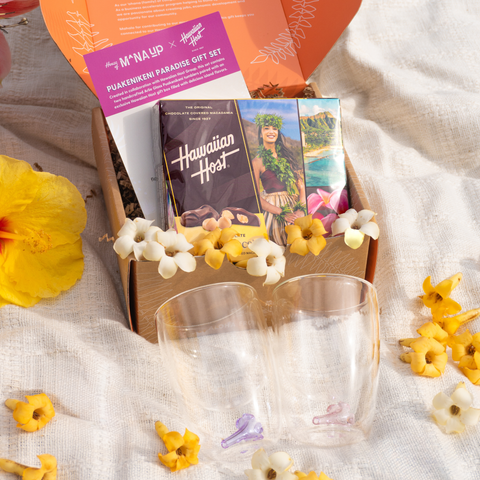 Hawaiian Host box with two clear tumblers, and a card on a textured surface with flowers.