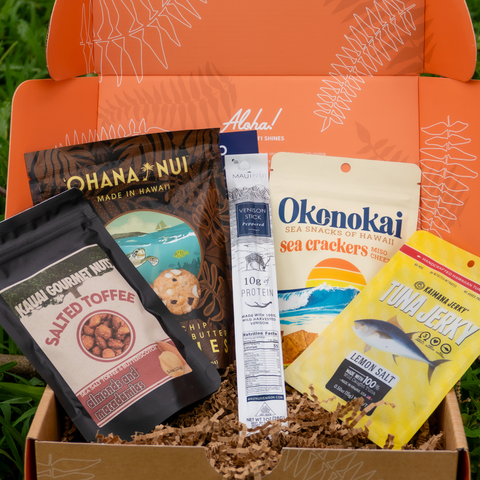 Assorted snacks in a box with visible branding on an orange background