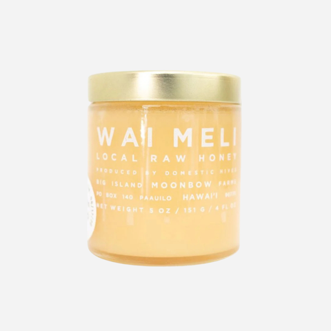 Jar of Wai Meli local raw honey with a gold lid on a white background