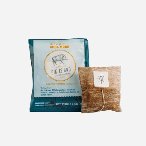 A packaged single-serve Kona Moon coffee pod by Big Island Coffee Roasters, showing both the outer cardboard packaging and the inner compostable sachet.